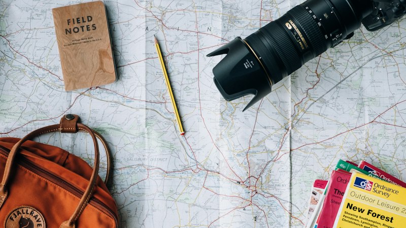 International travel destination research and global tourist route planning with world map and travel essentials
