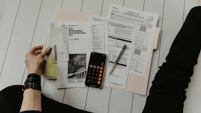 Business calculation of tour package margins and financial pricing documents on desk